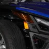 Close-up of a vehicle's front wheel and headlight area with black and blue accents.