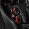 Close-up of a car interior with red-accented gauges on a carbon fiber panel.