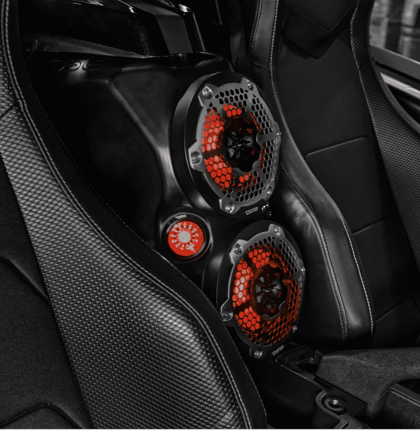 Close-up of a car interior with red-accented gauges on a carbon fiber panel.