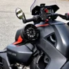 Close-up of a black and orange Can-Am motorcycle handlebar and side mirror.