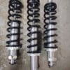 Three black coil springs with silver shock absorbers lined up.