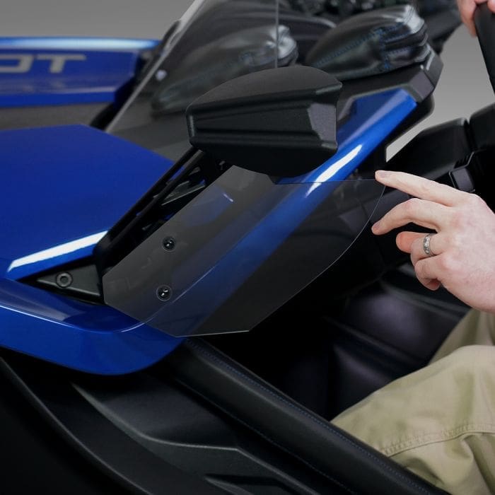 Person opening a storage compartment on a blue vehicle.
