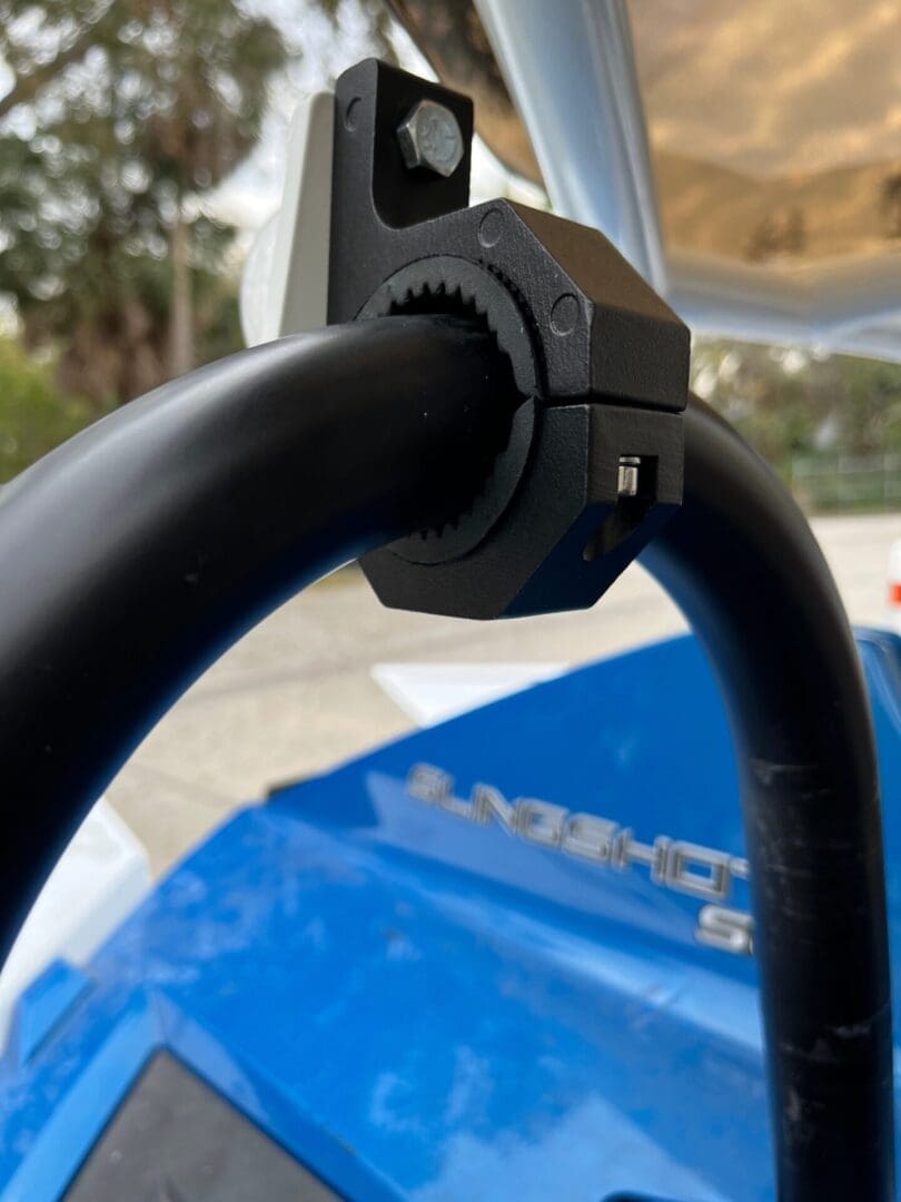 Close-up of a black handlebar with a textured grip outdoors.