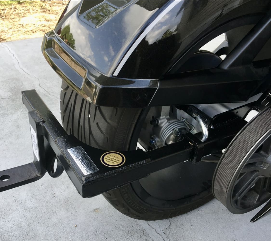 Close-up of a black wheelchair's rear section showing the wheel and frame details.