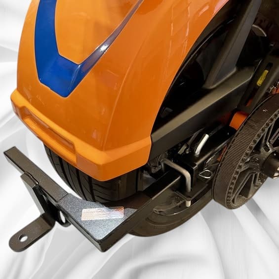 Close-up of an orange and black lawn mower's front part.